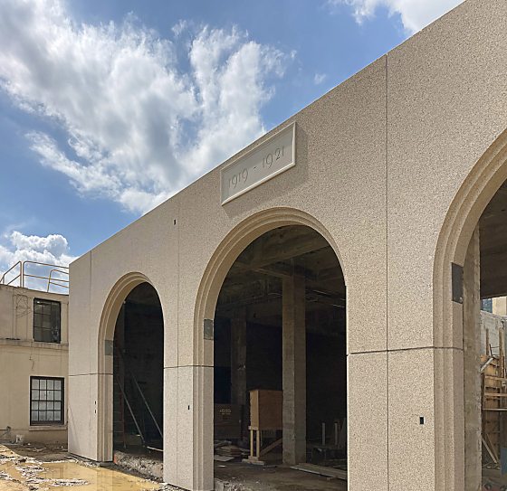 a beige stone wall with arches and a date plate that reads 1919 to 1921